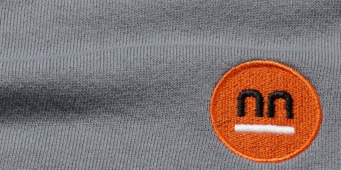 Gray fabric made of 100% organic cotton with Pamuuc isotope orange embroidered logo.